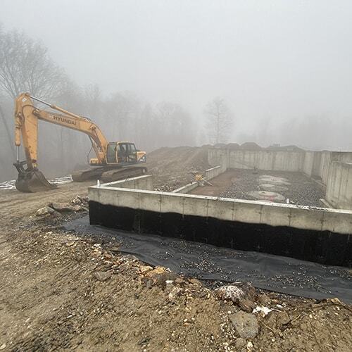 Excavator on site next to foundation in Great Barrington, MA